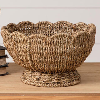 Close-up detail of woven seagrass texture and decorative scalloped rim on large pedestal bowl