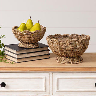 Natural seagrass fruit bowls holding green pears on stacked vintage books coastal farmhouse decor