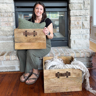 Woman sitting by fireplace holding rustic mango wood storage box