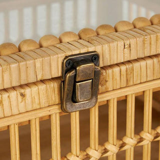 Close-up detail of bronze metal latch closure on natural rattan storage box with rounded bamboo trim