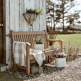 Rustic outdoor bench with decorative metal planters