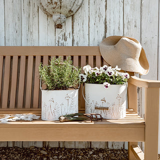 Decorative white planters styled on wooden garden bench