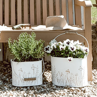 Decorative white planters styled on wooden garden bench