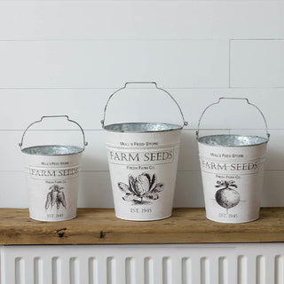 Set of three white distressed Farm Seeds metal buckets