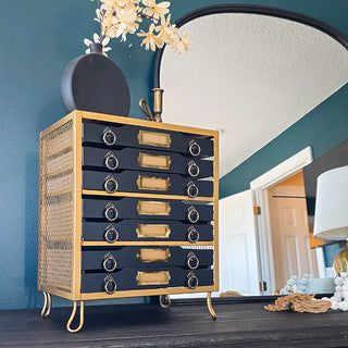 Navy and gold apothecary cabinet on dresser