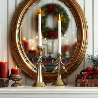 Set of two gold metal bow taper candle holders in different sizes 4x7 and 4x9 inches showing Victorian cottage core Christmas wedding decor with metallic finish

