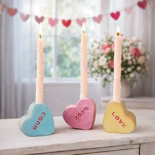 Two clay conversation heart bud vases in yellow XOXO and pink LOVE with pink flowers on farmhouse coffee table Valentine living room decor