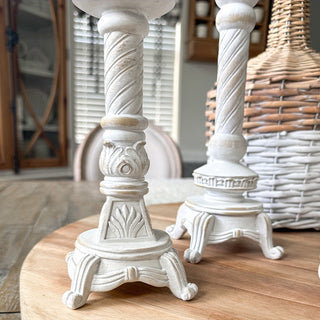 Close-up distressed white resin candlestick bases
