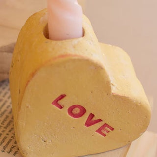 Close up pink LOVE clay conversation heart vase showing distressed texture and hand-painted red lettering Valentine decor detail
