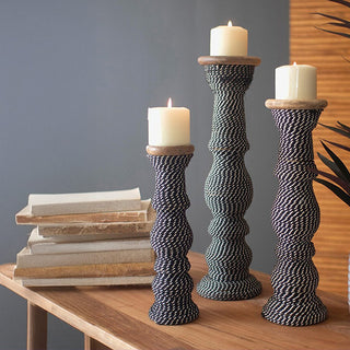 Tall rope candle holders on wooden table