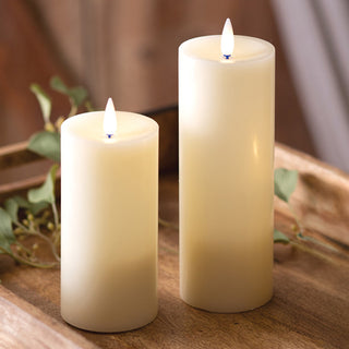 Close up of two flickering LED pillar candles with realistic flame effect on wooden tray