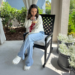 Woman sitting on black outdoor rocking chair
