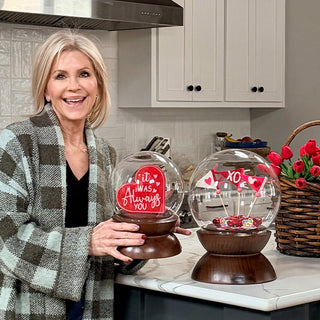 Woman holding decorative glass cloche with wood base showcasing versatile styling options for home décor