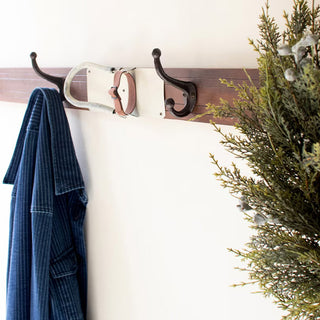 Handcrafted style ski coat rack with metal hooks and unique wood grain for entryway