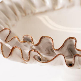 Ruffled ceramic bowl edge close-up gold trim