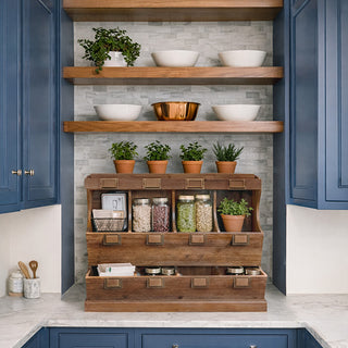 Kitchen with wooden samplers counter and storage unit against a gray tiled wall.