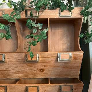 Wooden cabinet with decorative greenery on top; samplers counter