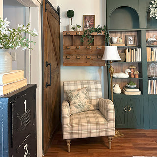 Cozy living room with plaid armchair, bookshelf, and decorative elements. samplers counter