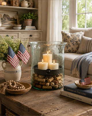 Decorative setup with candles, American flags, and books in a cozy living room.
