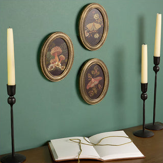 Vintage botanical wall decor above desk with candles