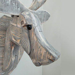 Close-up of rustic wooden deer head carving