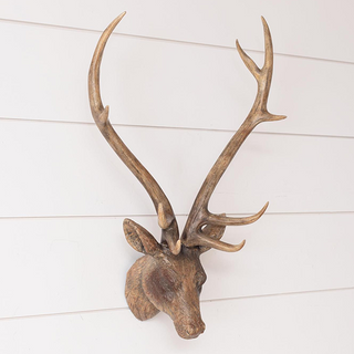 Antique brown distressed deer head wall sculpture with dramatic antler span mounted on white shiplap farmhouse wall rustic lodge decor