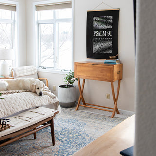 Full view of natural wood secretary desk with X-leg base in contemporary home setting