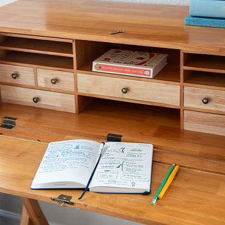 Interior storage organization showing multiple small drawers and cubbies inside secretary desk