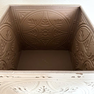 Detailed corner of antique-inspired metal and wood table with patina finish