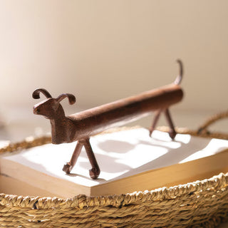 Decorative metal dachshund sculpture on stacked books