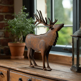 Distressed metal elk statue styled on wooden cabinet