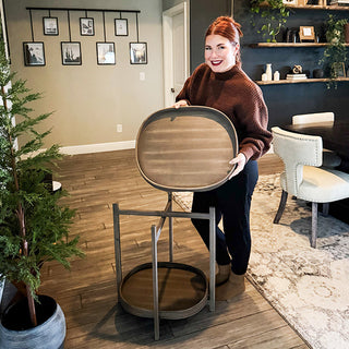 Full view of woman demonstrating removable tray feature on two-tier oval end table in modern living room