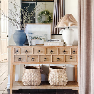 Close-up of stacked faux book storage boxes with titles Bespoke Furniture, Modern Design, and 19th Century Drawings used as decorative home accents.