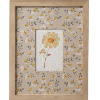 Close-up of yellow pressed flower watercolor print with coordinating floral pattern matte in wood frame
