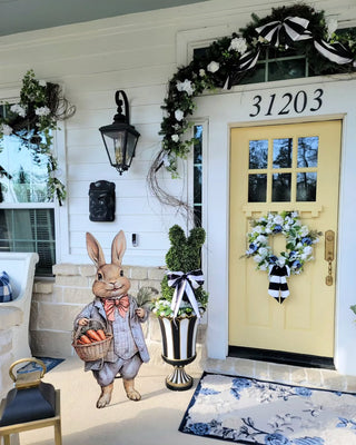 bunny sign in front of yellow front door with bunny topiaries in planters easter decor and spring decor on front porch