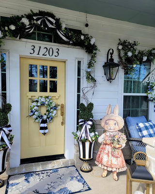 bunny sign in front of yellow front door with bunny topiaries in planters easter decor and spring decor on front porch