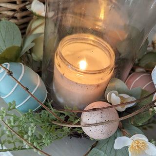 Close-up spring candle with decorative eggs and greenery