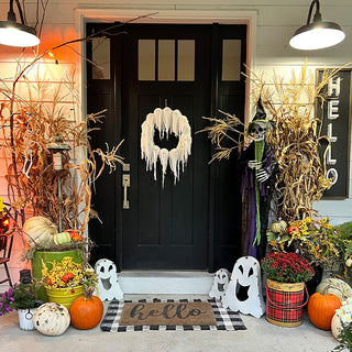 Front porch decorated for Halloween with ghost metal candle holders