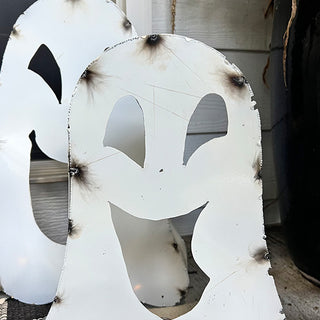 Close-up of distressed white metal ghost Halloween decoration