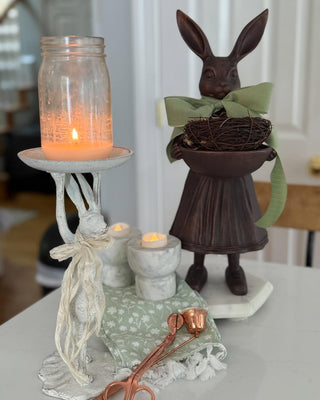 Full view Female Royal Hare statue bronze finish resin pleated dress mary jane shoes holding decorative bowl wearing green bow and holding bowl with nest of eggs