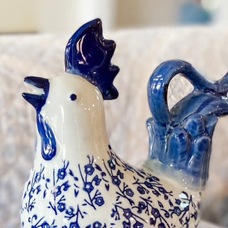 Ceramic chicken figurine with blue and white floral pattern on a blurred background