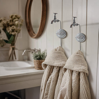Farmhouse bathroom wall with two vintage faucet-style towel hooks