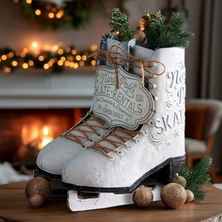 Decorative North Pole skate rentals metal ice skates filled with pine greenery and gold ornaments, displayed on a wooden table in front of a cozy holiday fireplace