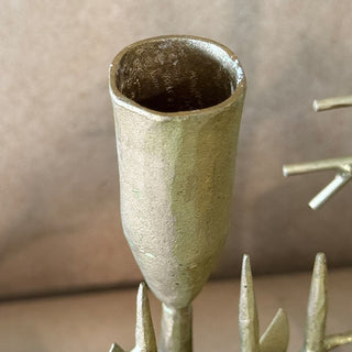 Close-up view of the gold metal taper candle holder cup showing textured forged-iron craftsmanship