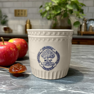 Collection of vintage white stoneware pots with blue Frameries Belgium logo stacked on blue shelf, farmhouse kitchen storage display