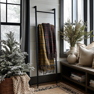 Nestled corner of a room with a blanket ladder, potted plants, and a bench.