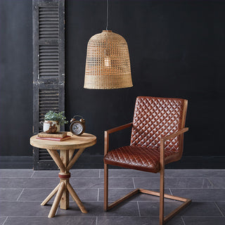 Coastal style natural grass bell pendant in modern living space with leather chair