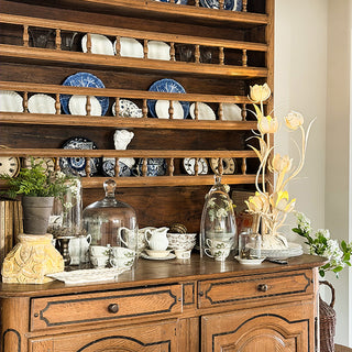 Cordless metal flower lamp with six illuminated tulip blooms and distressed patina on wooden sideboard