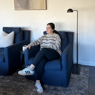 Woman seated next to modern black floor lamp