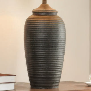 Close-up of Charlotte matte black lamp textured resin base on wooden side table